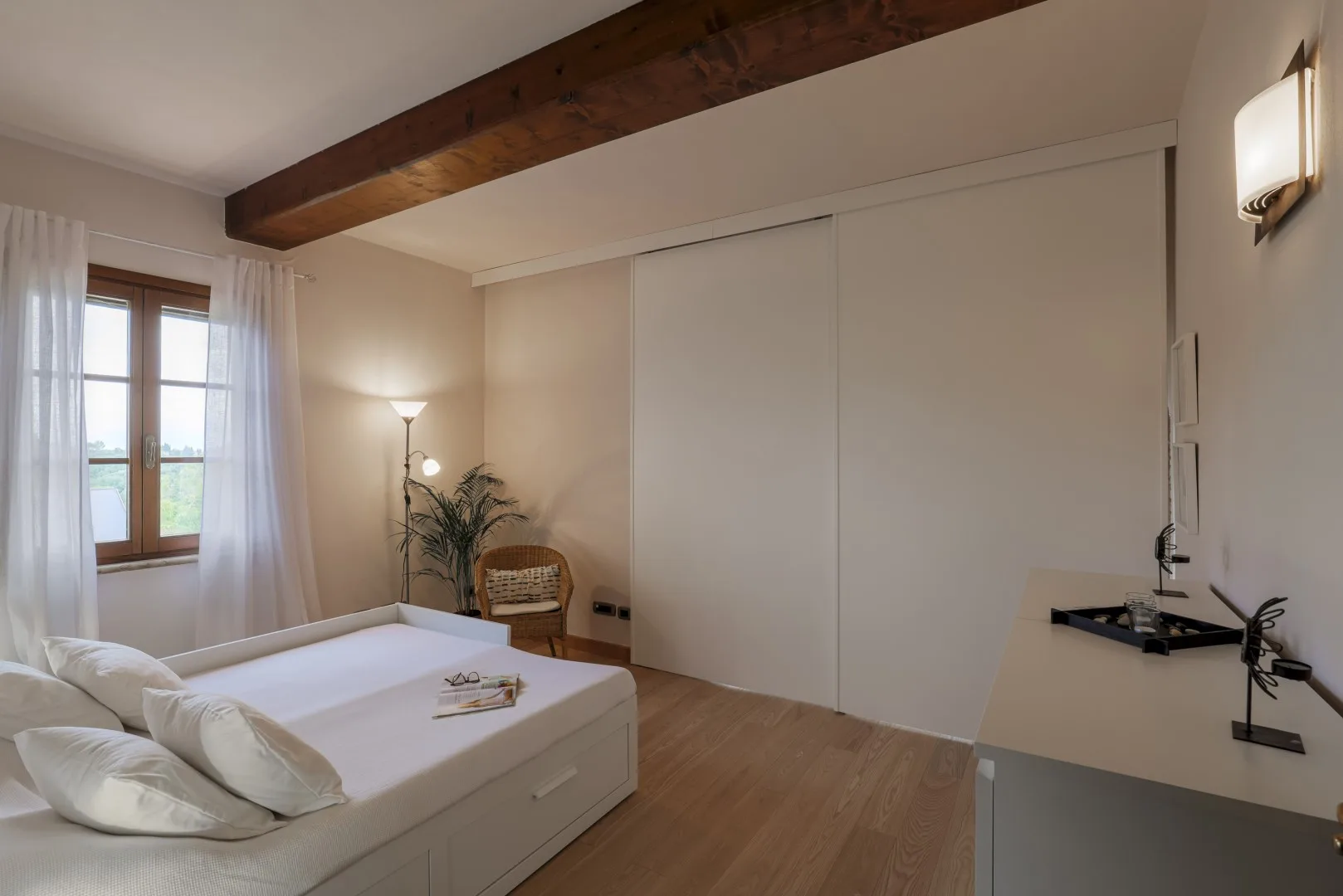 Un dormitorio con una cama, una ventana y un armario grande.