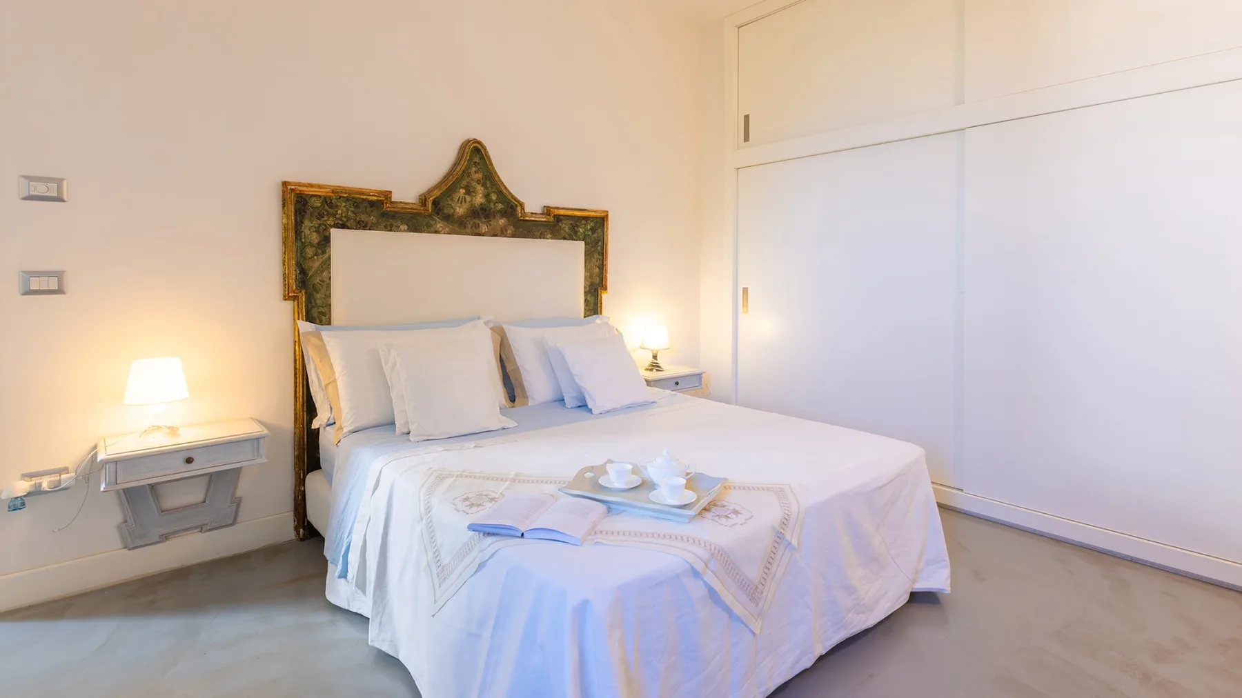 Un dormitorio con una cama bien tendida y un cabecero decorativo.