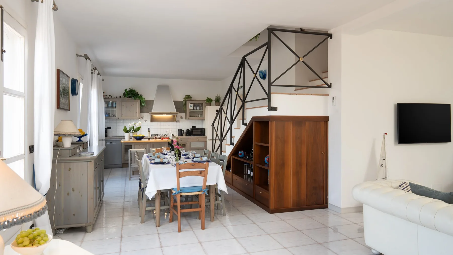An open-plan living and dining area with a dining table and television.