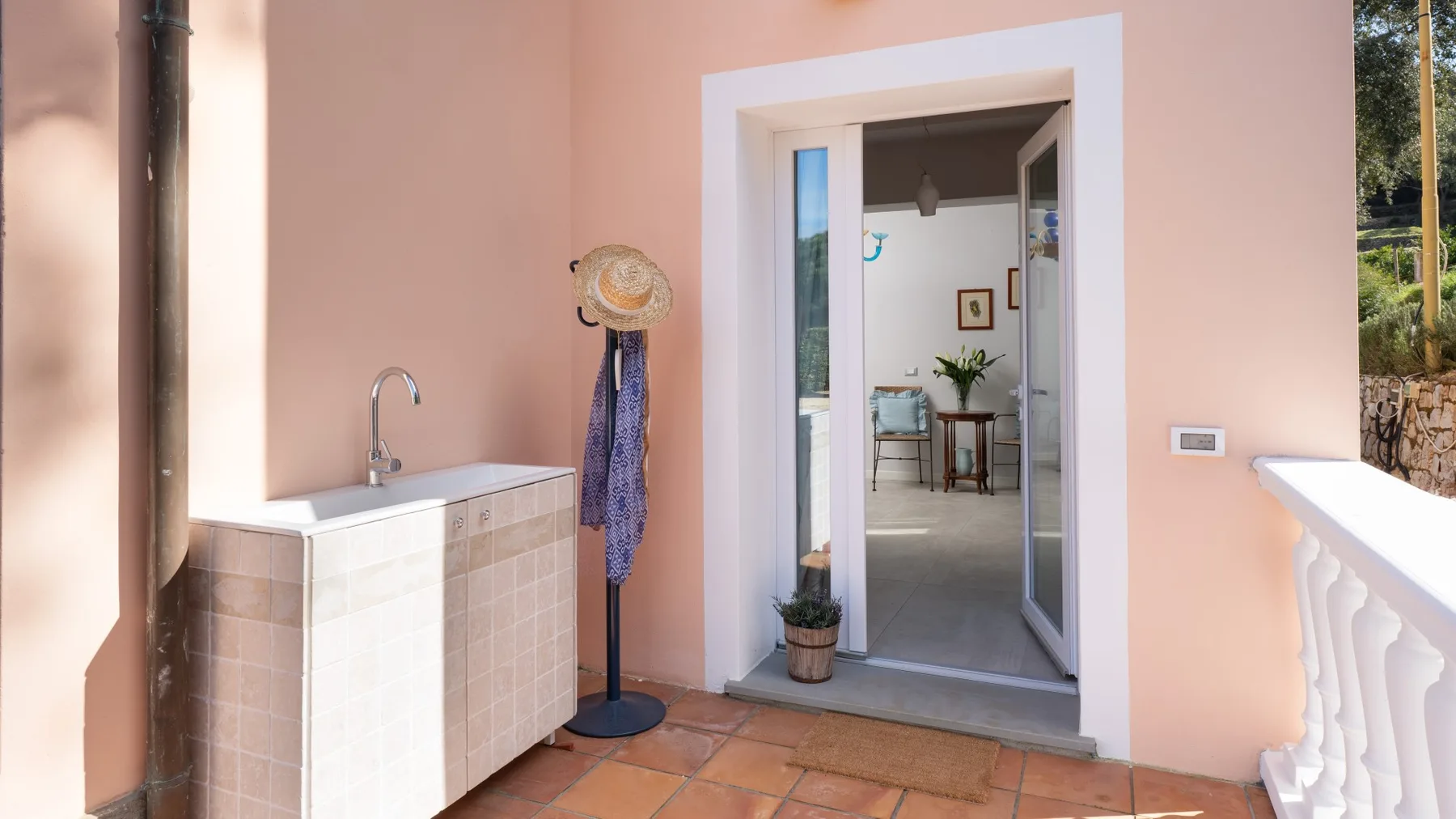A peach-colored terrace with a tiled counter and a doorway opening into an interior room.
