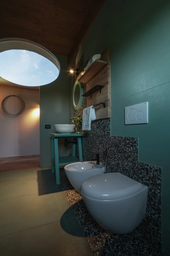 A modern bathroom with a wall-mounted sink and white toilet.