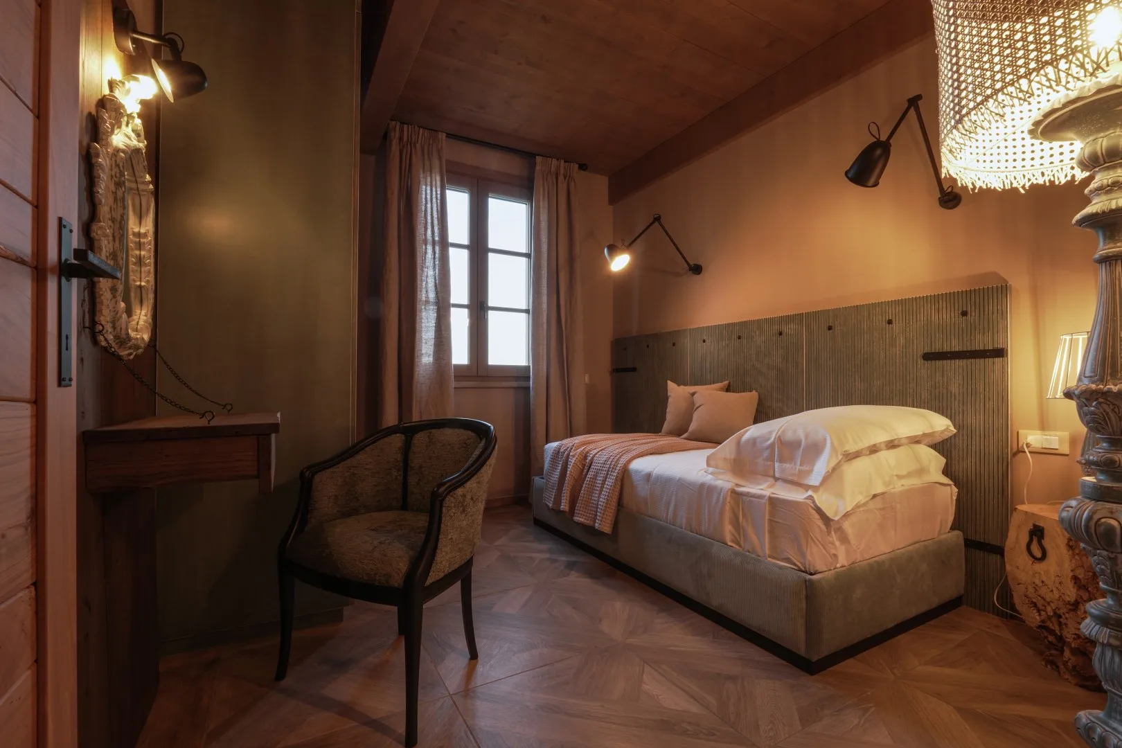 A bedroom with a bed, a window, and a chair.