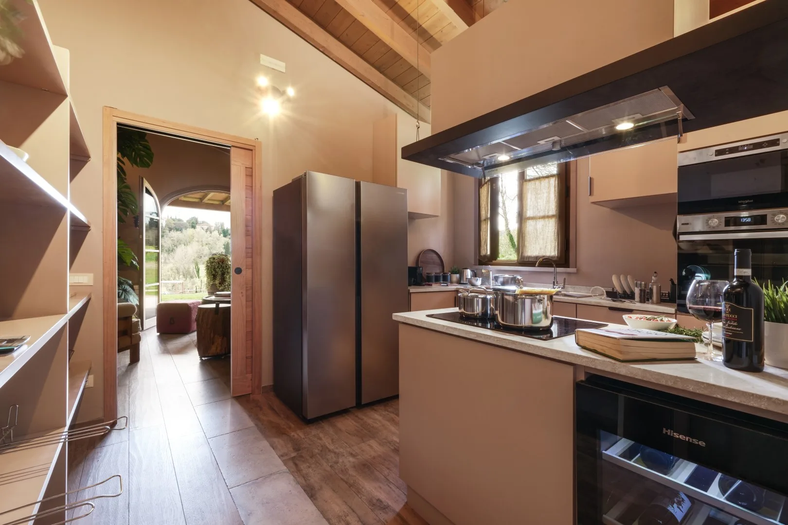 A spacious kitchen with a central island, stainless steel appliances, and a window.