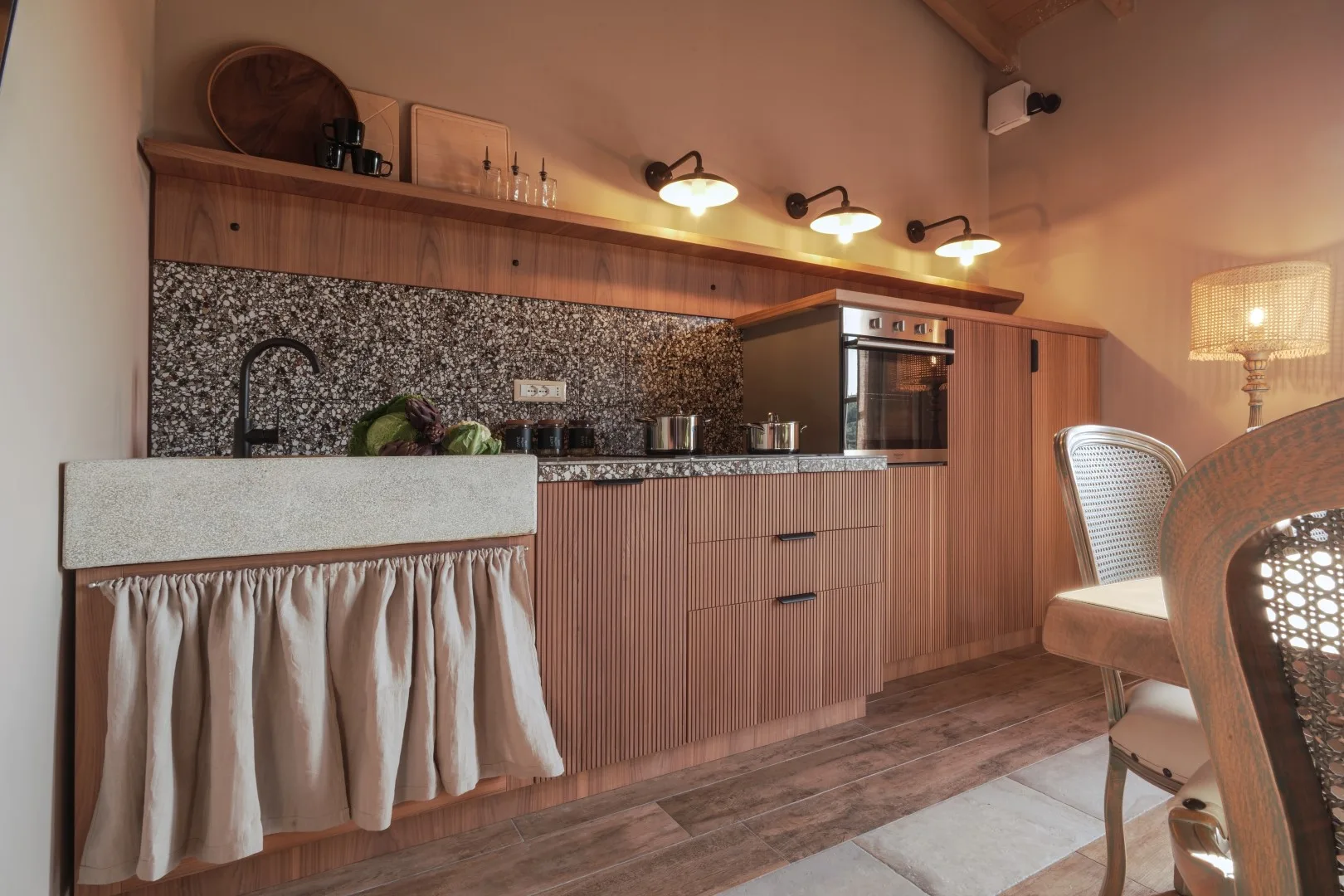 A kitchen with wooden cabinetry, a dark backsplash, and a countertop.