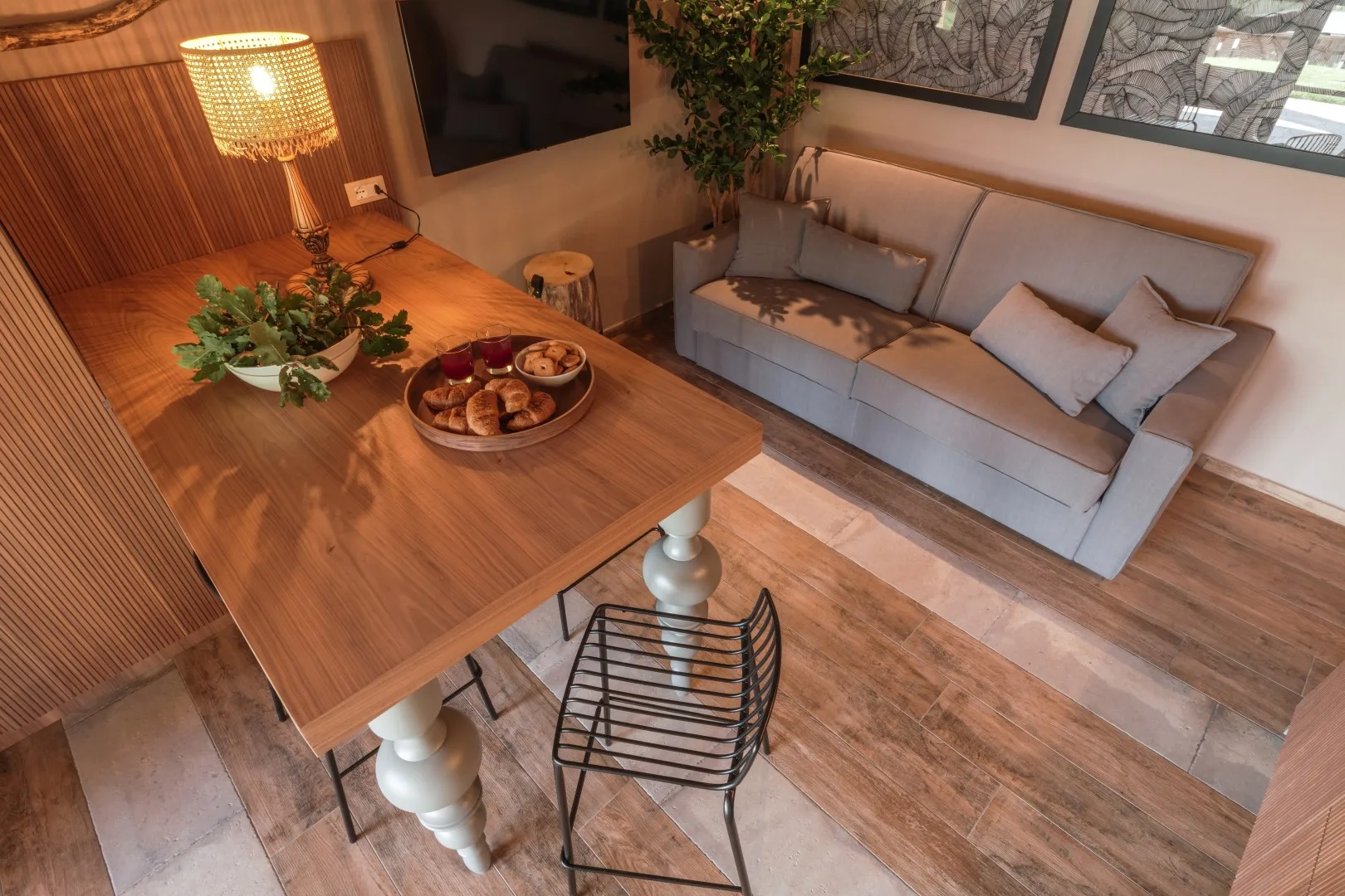 A living room with a gray sofa, wooden table, and warm lamp.