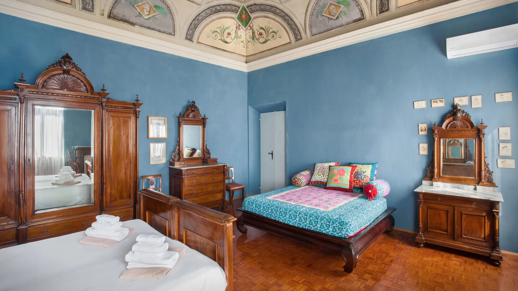 A bedroom with a bed, wooden furniture, and blue walls.