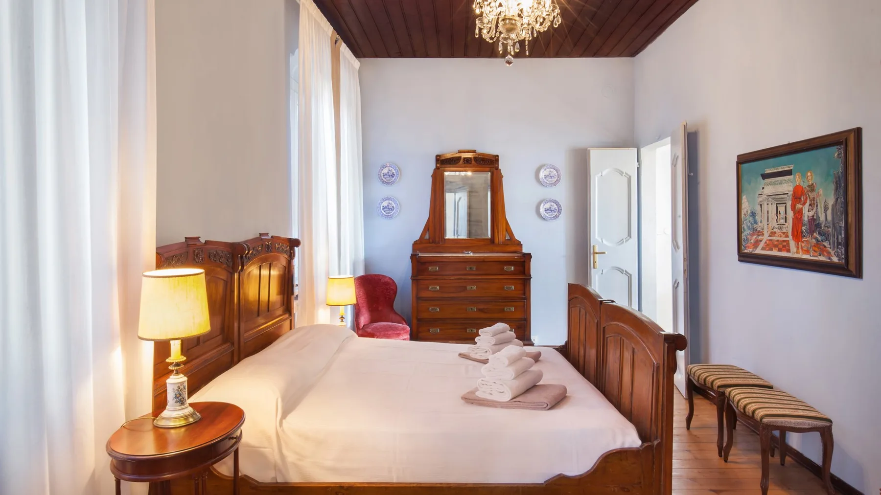 A bedroom with a wooden bed, bedside lamps, and a dresser.