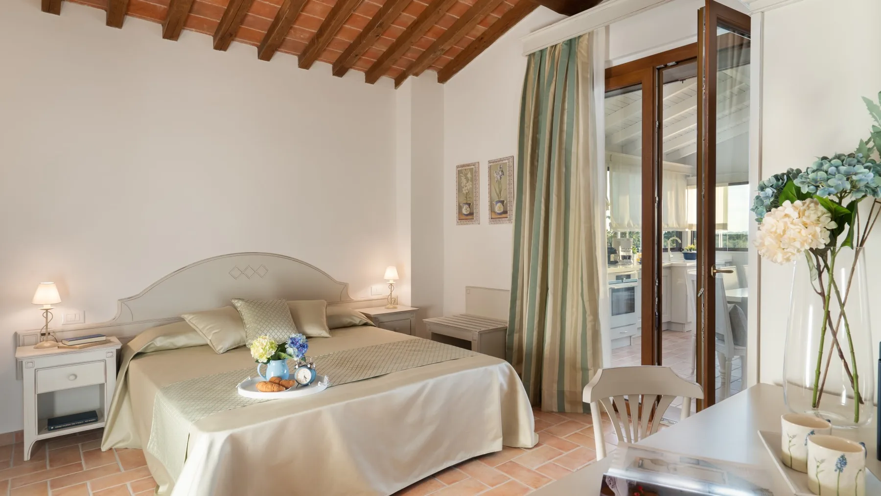 A bedroom with a bed, bedside tables, and glass doors opening onto a balcony.