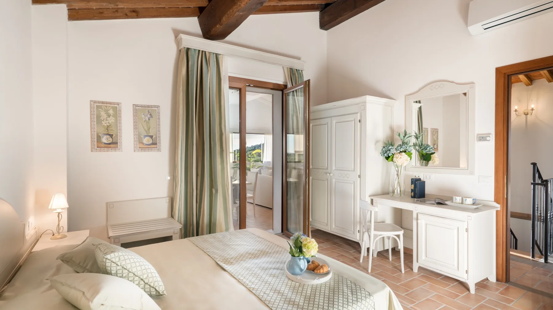 A bedroom with a bed, a wardrobe, and an open doorway to a balcony.