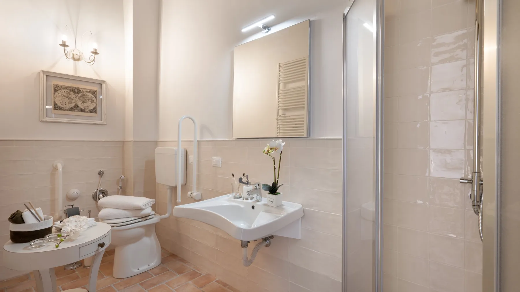 A bright bathroom with a sink, toilet, and glass shower.