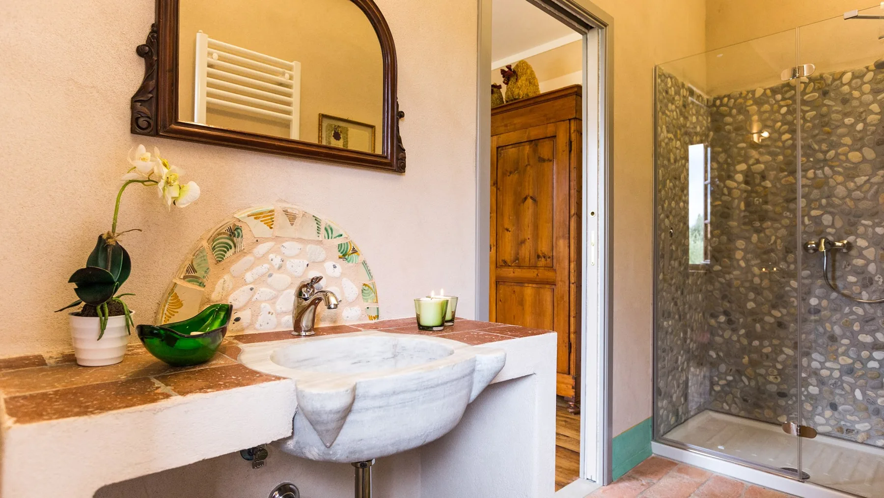 A bathroom with a sink, mirror, and glass shower.