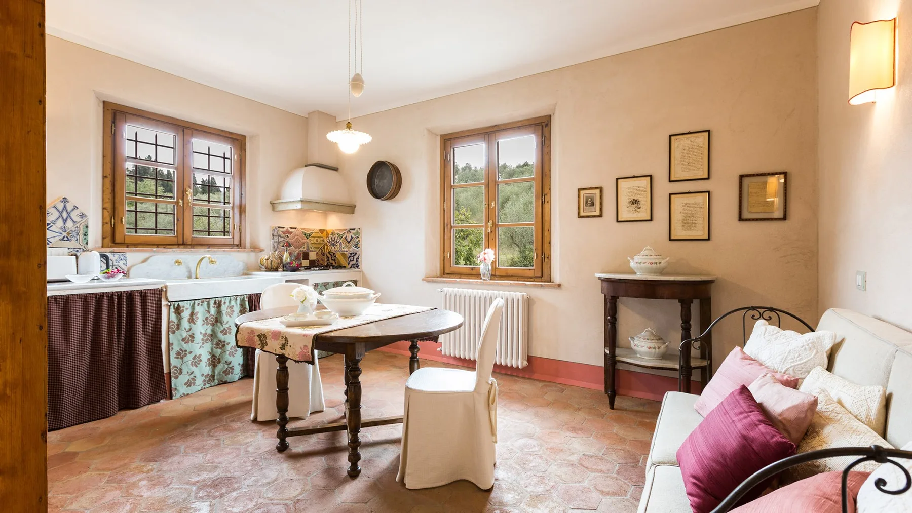 A bright dining area with a wooden table, kitchen counter, and windows.