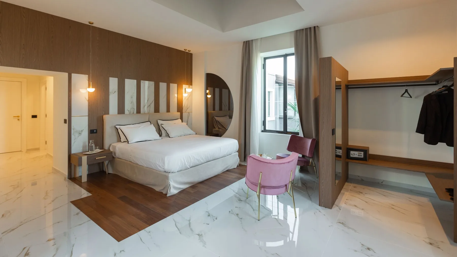 Un dormitorio con una cama, una pequeña zona de estar y un armario abierto.