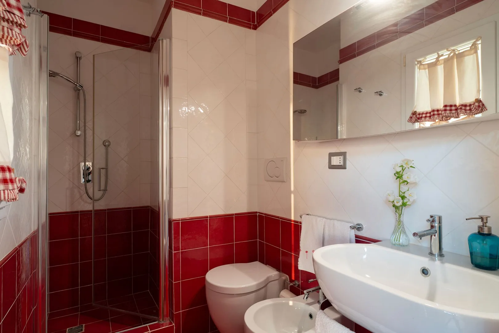 A tiled bathroom with a shower, toilet, and sink.