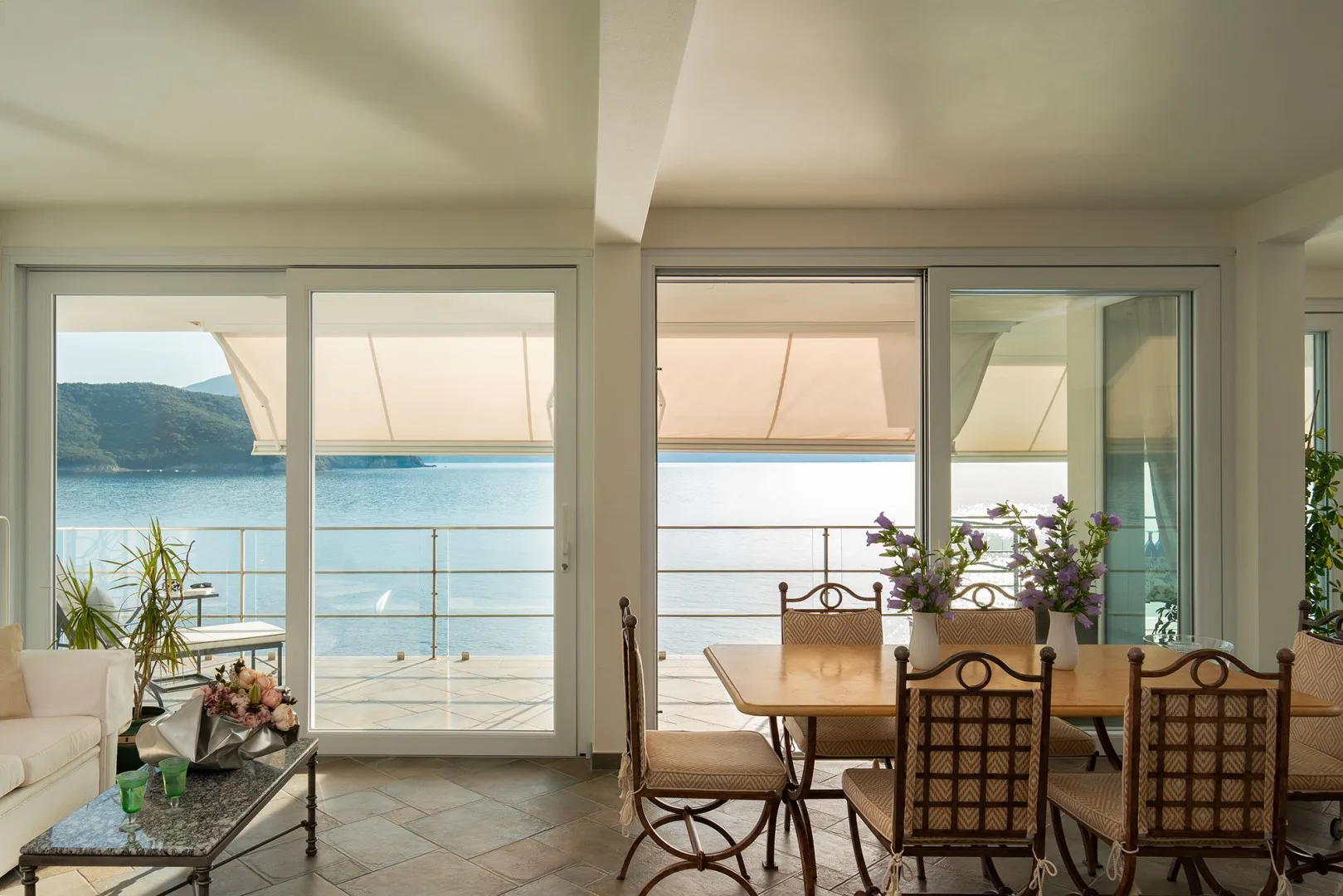 A dining area opens onto a terrace overlooking the water.