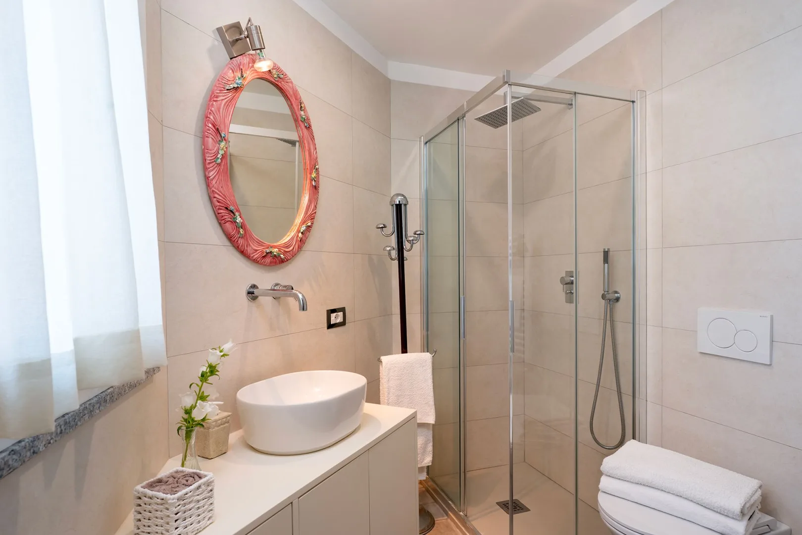 A bright tiled bathroom with a glass shower and a vessel sink.