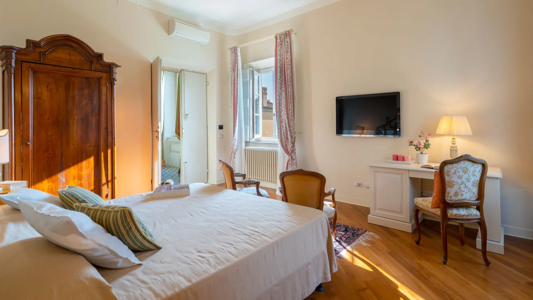 Un dormitorio con una cama grande, un televisor y un escritorio.