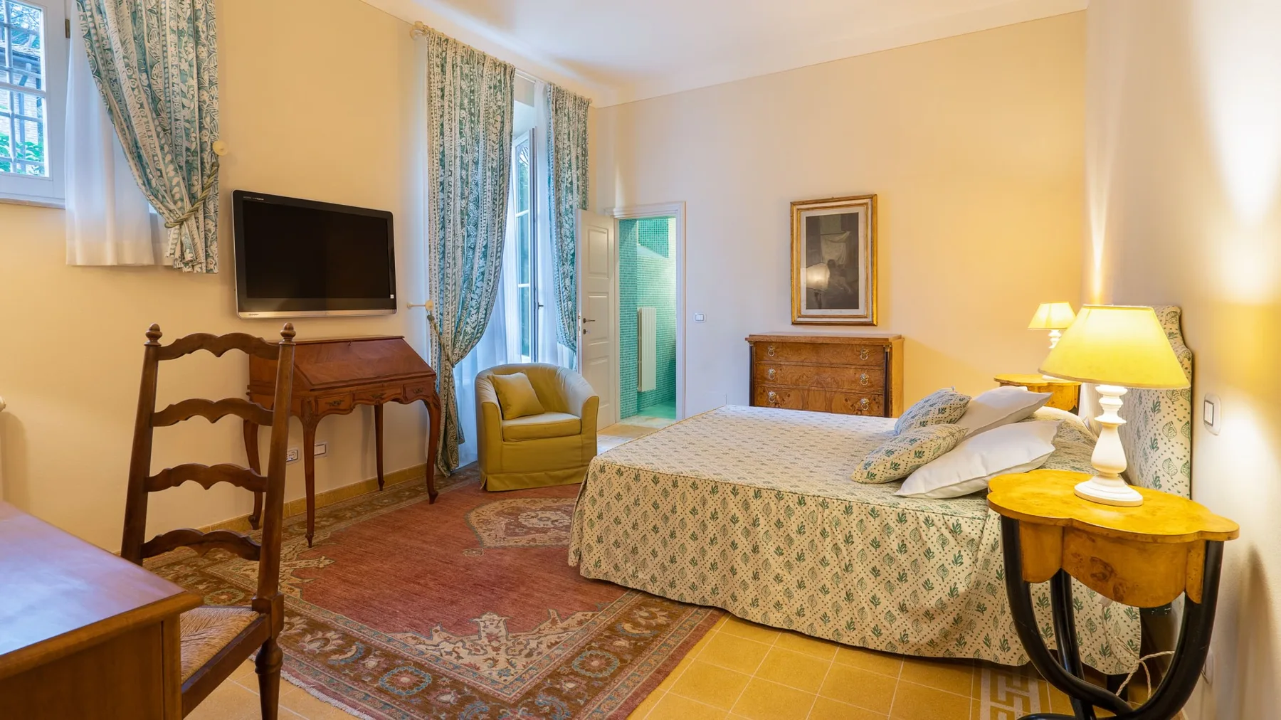 Un dormitorio con una cama estampada, muebles de madera y un televisor.