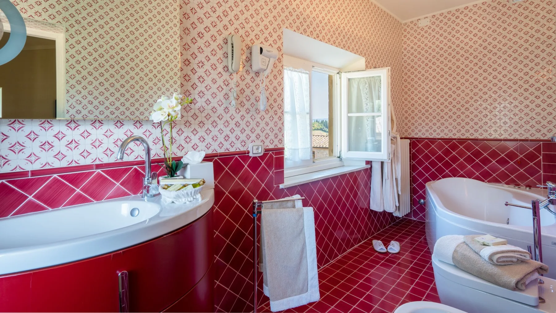 Un baño con lavabo curvo, bañera y ventana abierta.