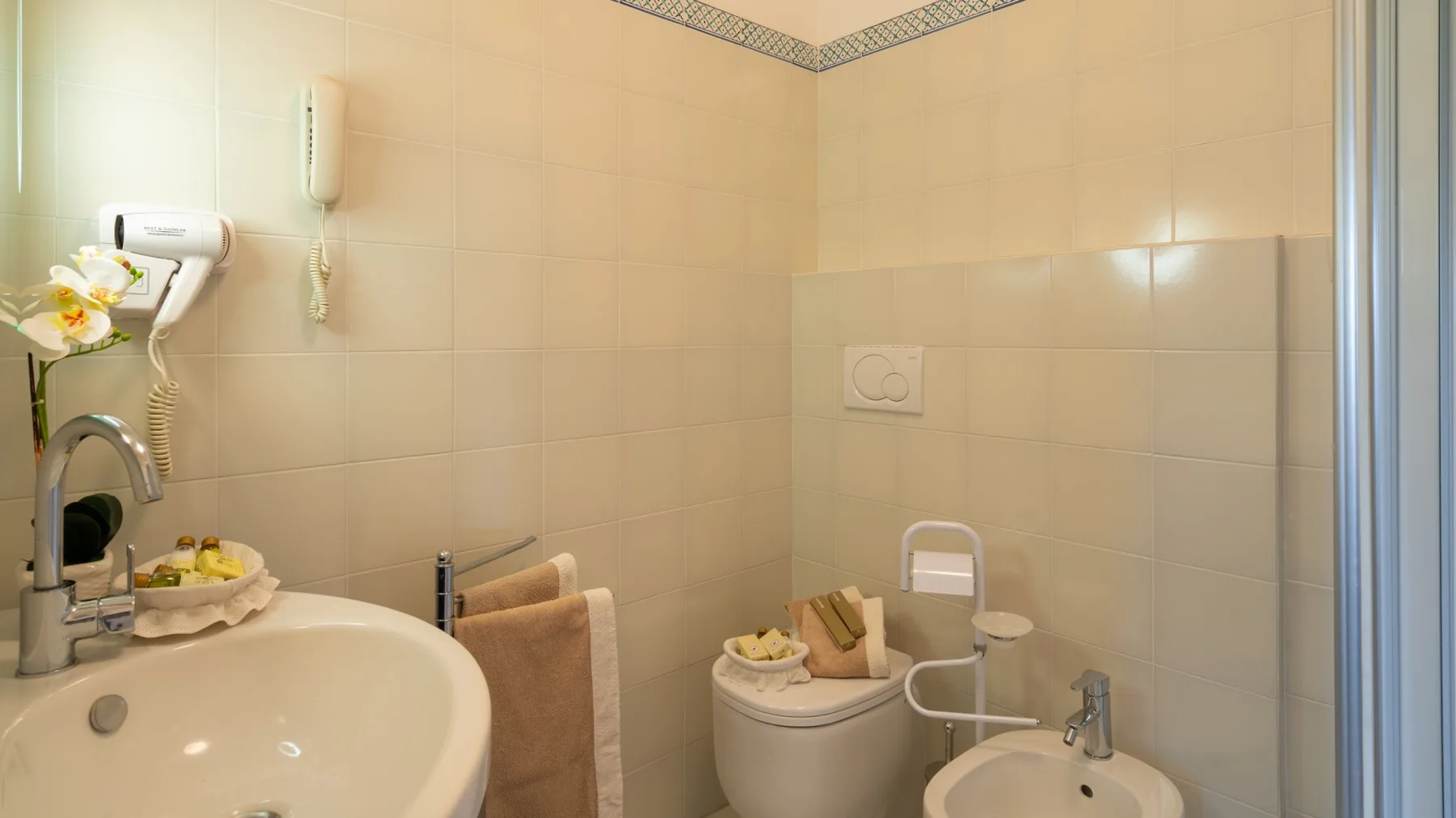Un baño alicatado con lavabo, inodoro y bidé.