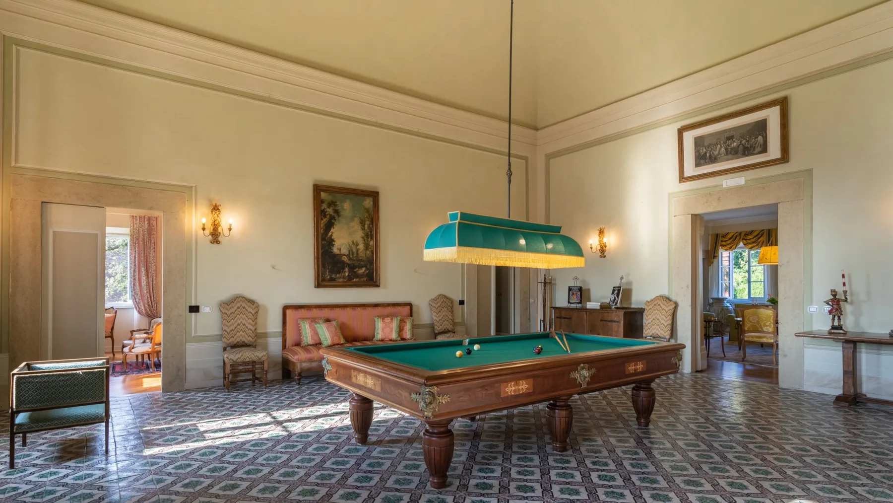 Una sala de billar formal con una mesa de paño verde y suelo estampado.