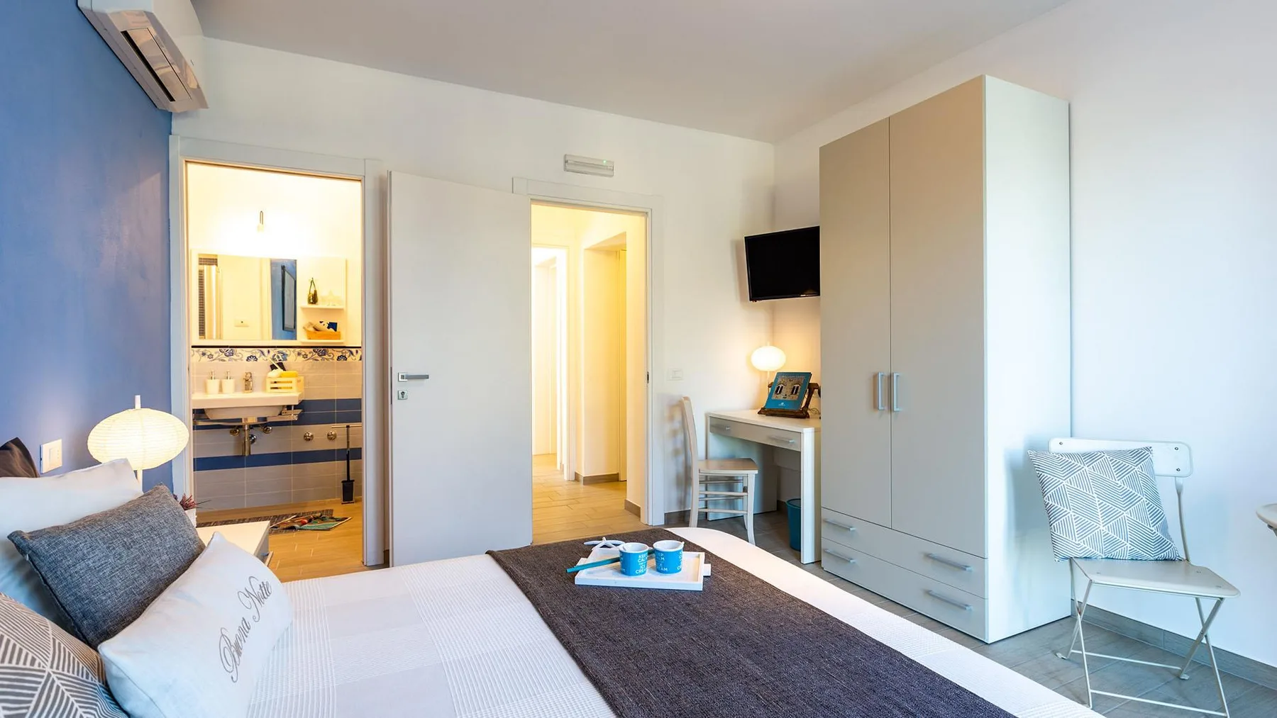 A bedroom with a bed, a wardrobe, and a desk beside the doorway.