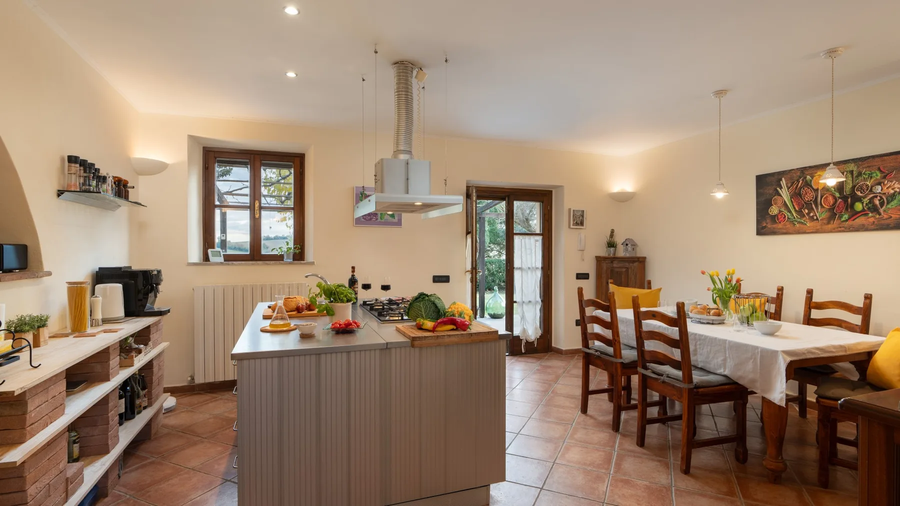 Una cocina y comedor con una isla central y una mesa de comedor larga.