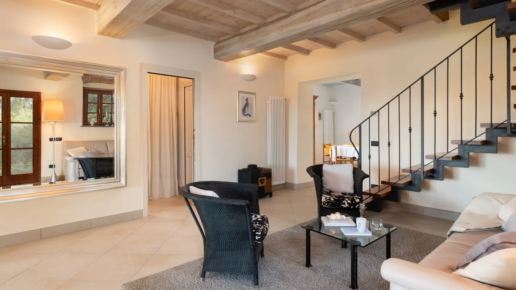 Una sala de estar con asientos y una escalera junto a la pared.