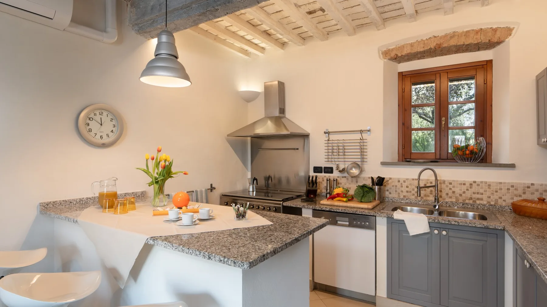 Una cocina luminosa con una barra central, una estufa y una ventana.