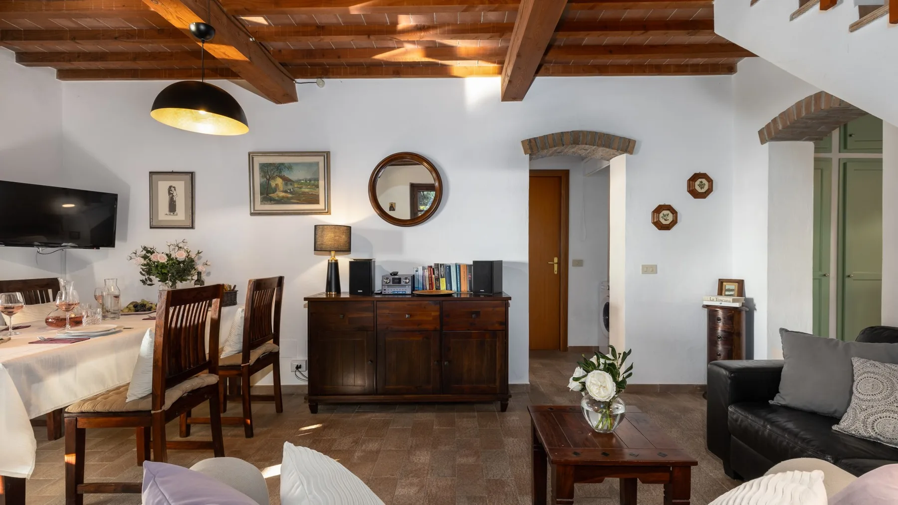 Una sala de estar y comedor con muebles de madera y un televisor.