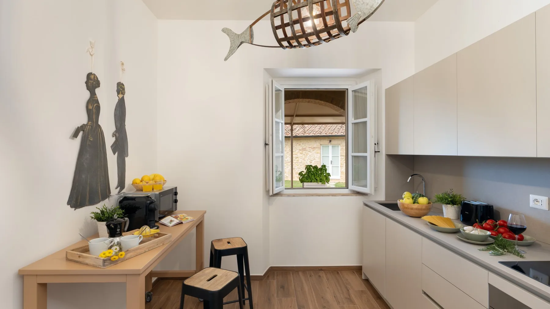A narrow kitchen with a wooden table and an open window.