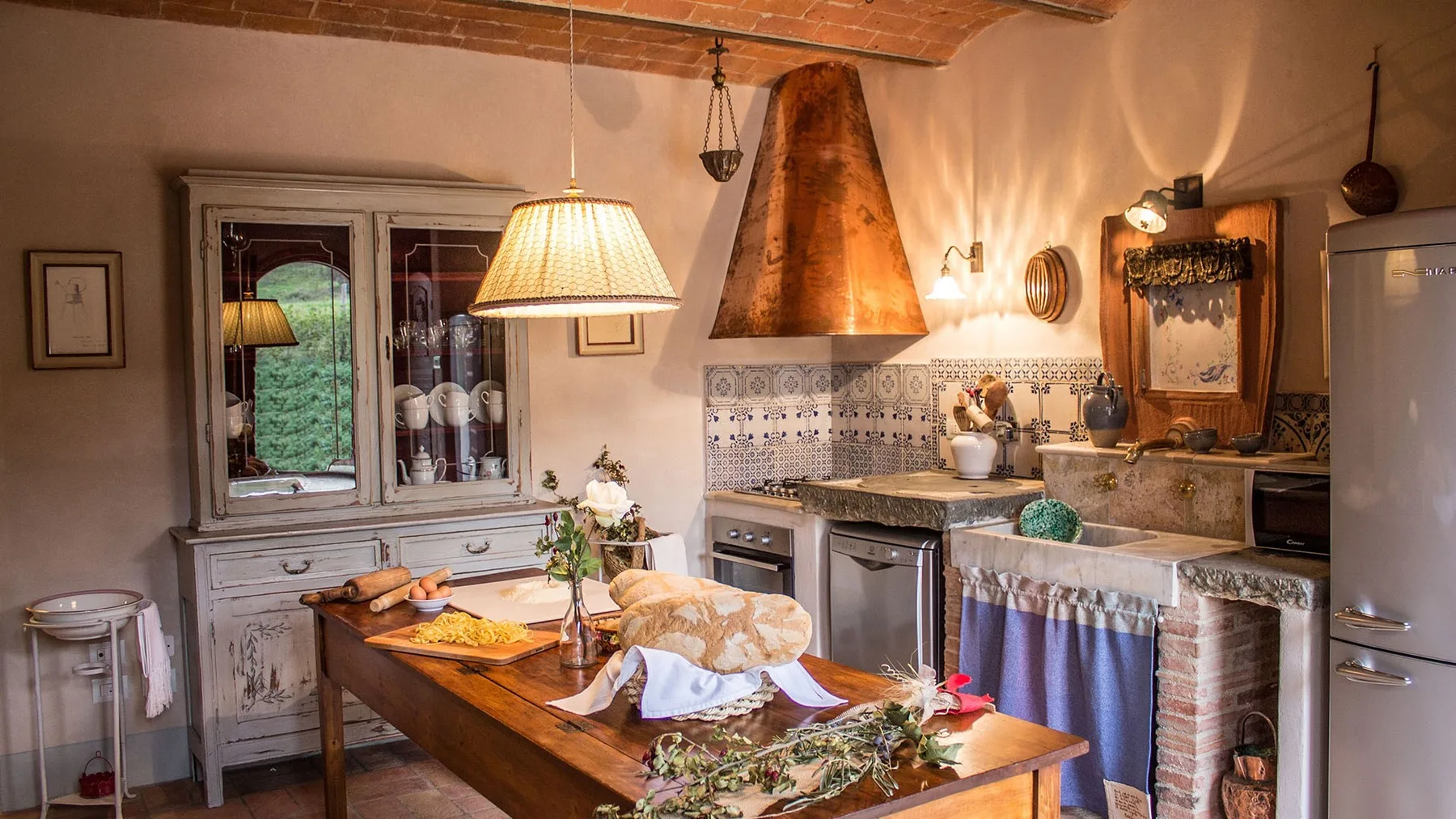A rustic kitchen with a wooden dining table and tiled cooking area.