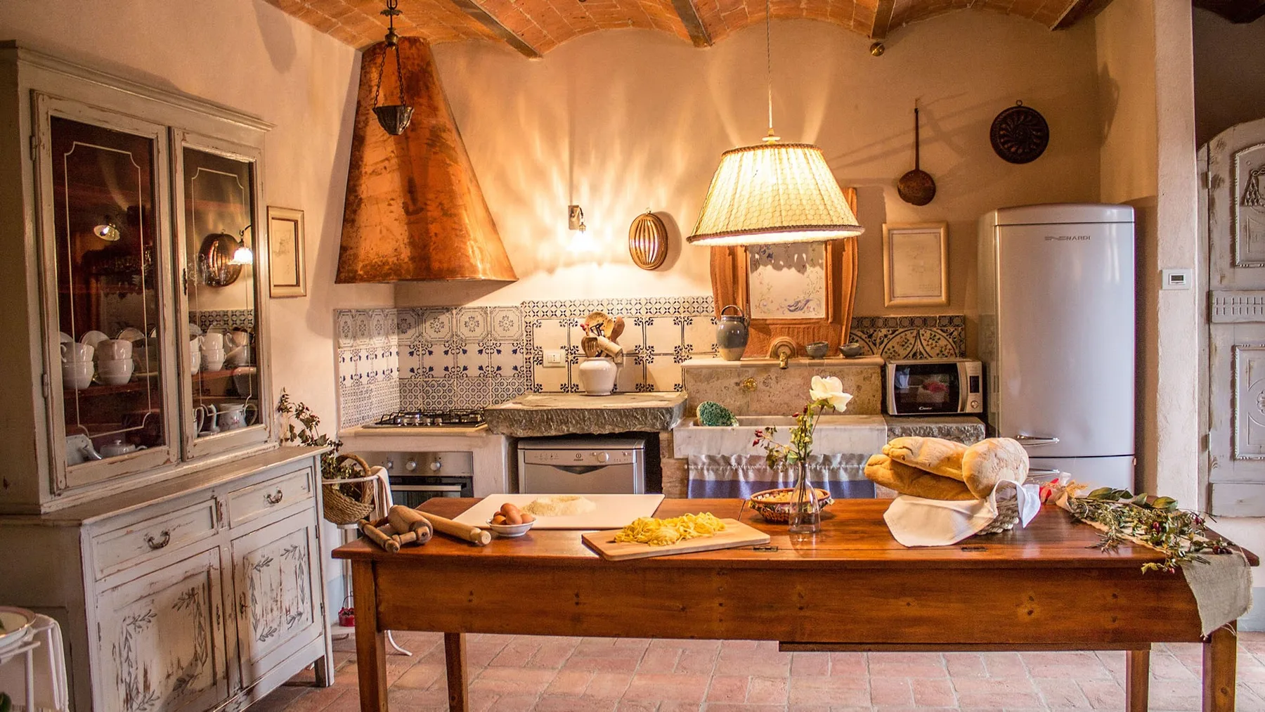 A rustic kitchen with a wooden island and tiled backsplash.