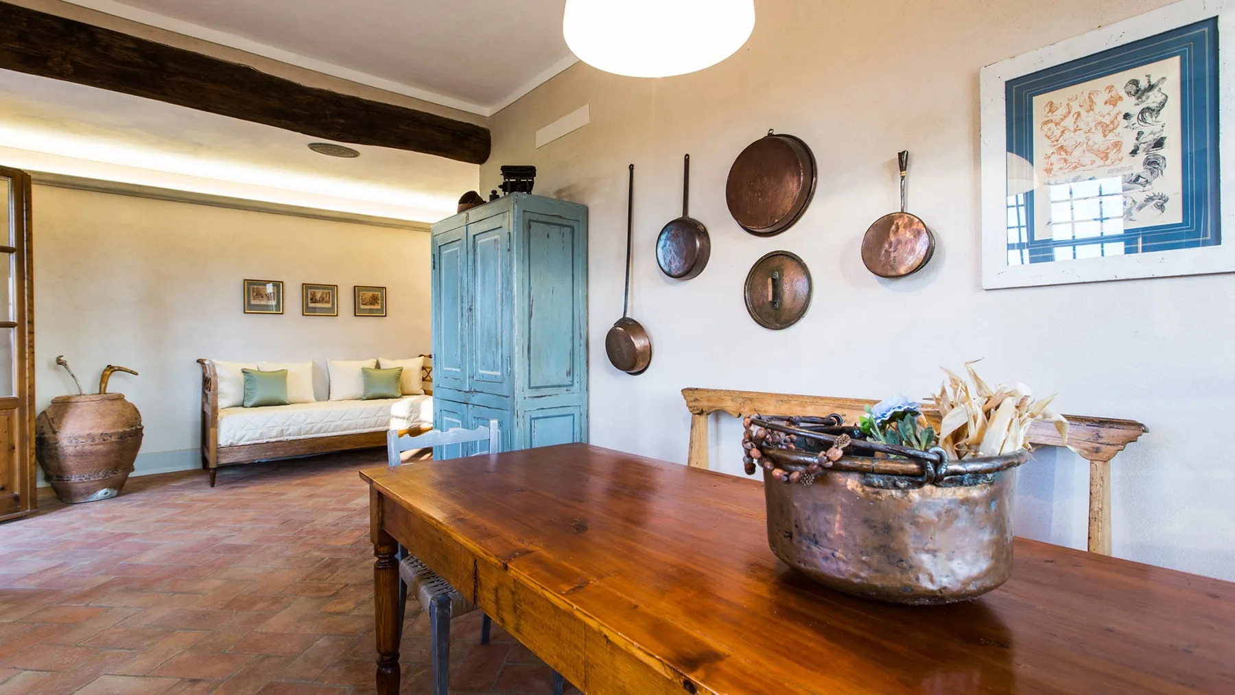 A rustic dining room with a wooden table and blue cabinet.