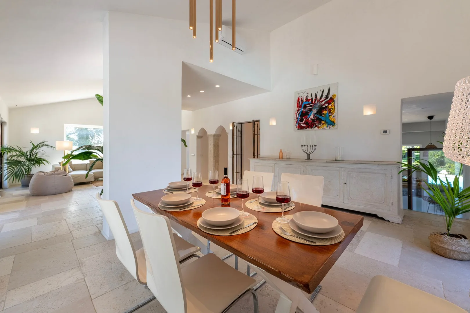 A bright dining area with a wooden table set beside a white built-in cabinet.