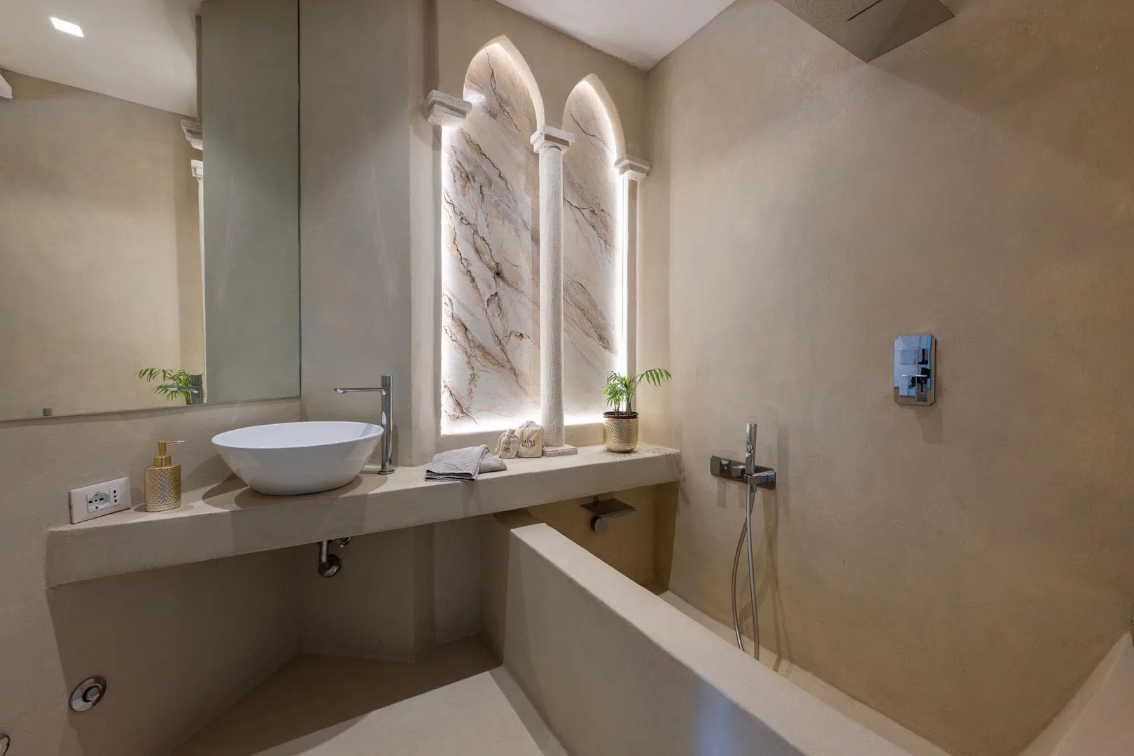 A bathroom with a long vanity, vessel sink, and bathtub.