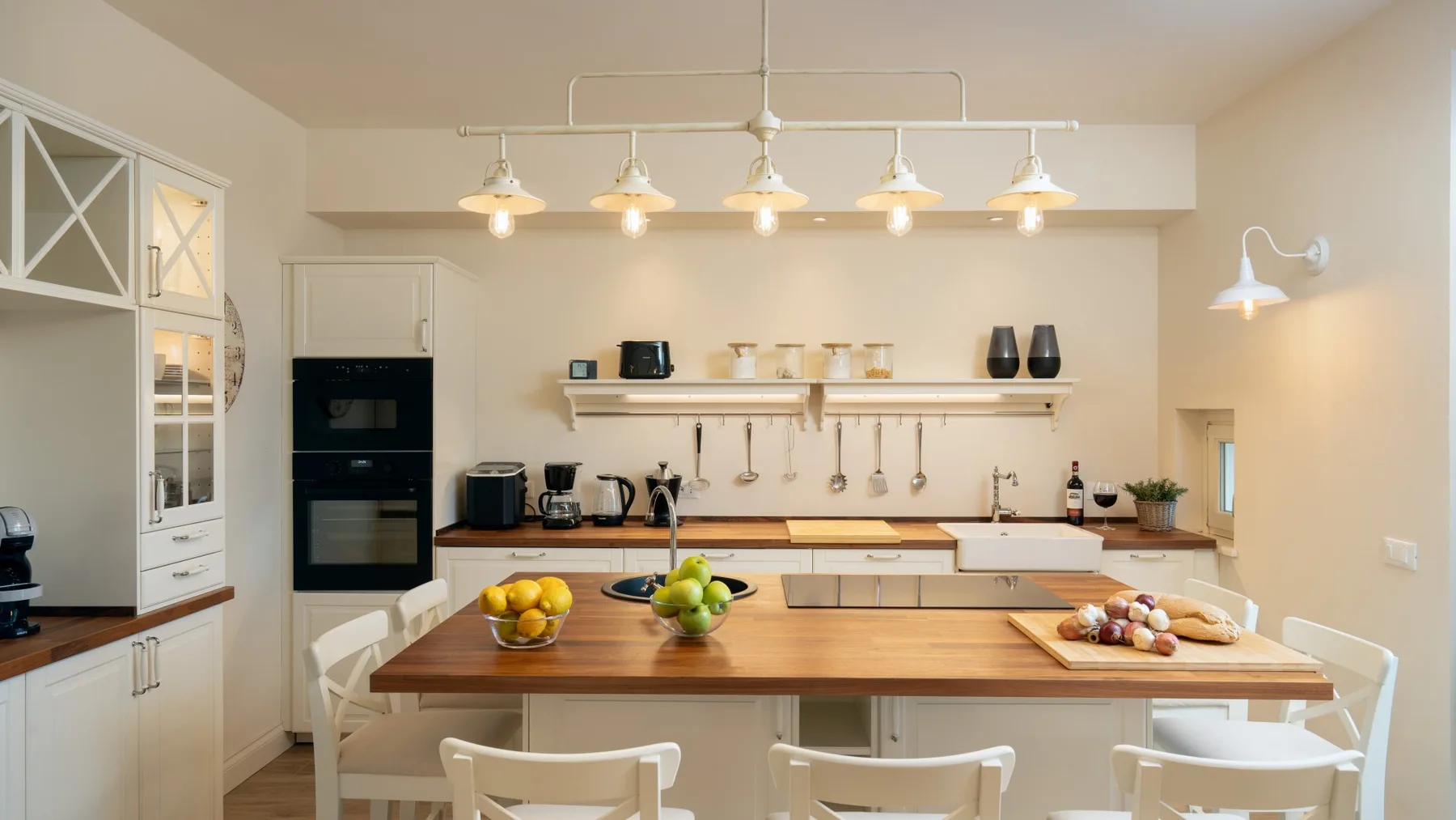 Una cocina luminosa con una isla grande y fruta sobre la encimera.
