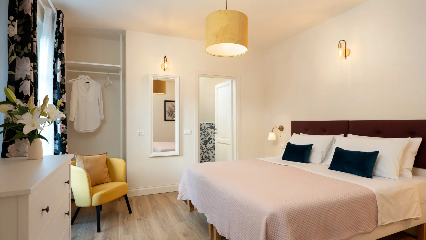 Un dormitorio con una cama grande, asientos amarillos y un área para vestirse.