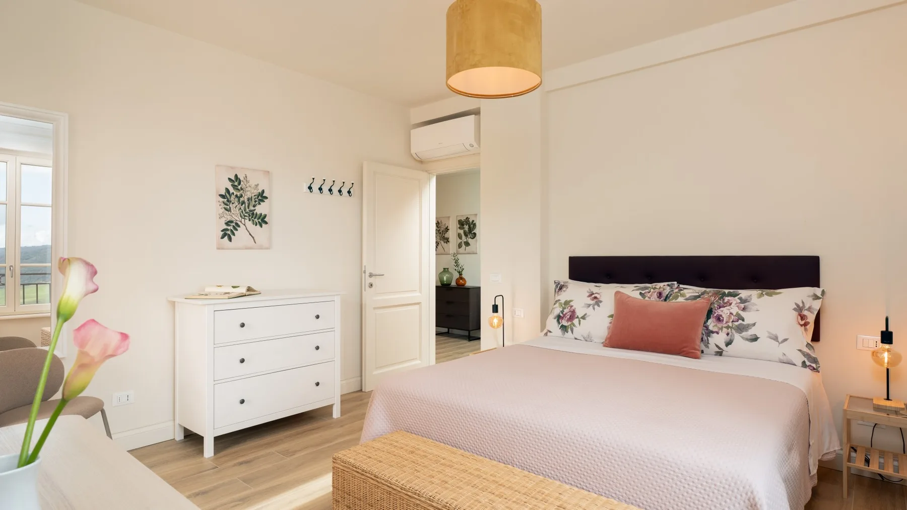 Un dormitorio con una cama, una cómoda blanca y una puerta abierta.