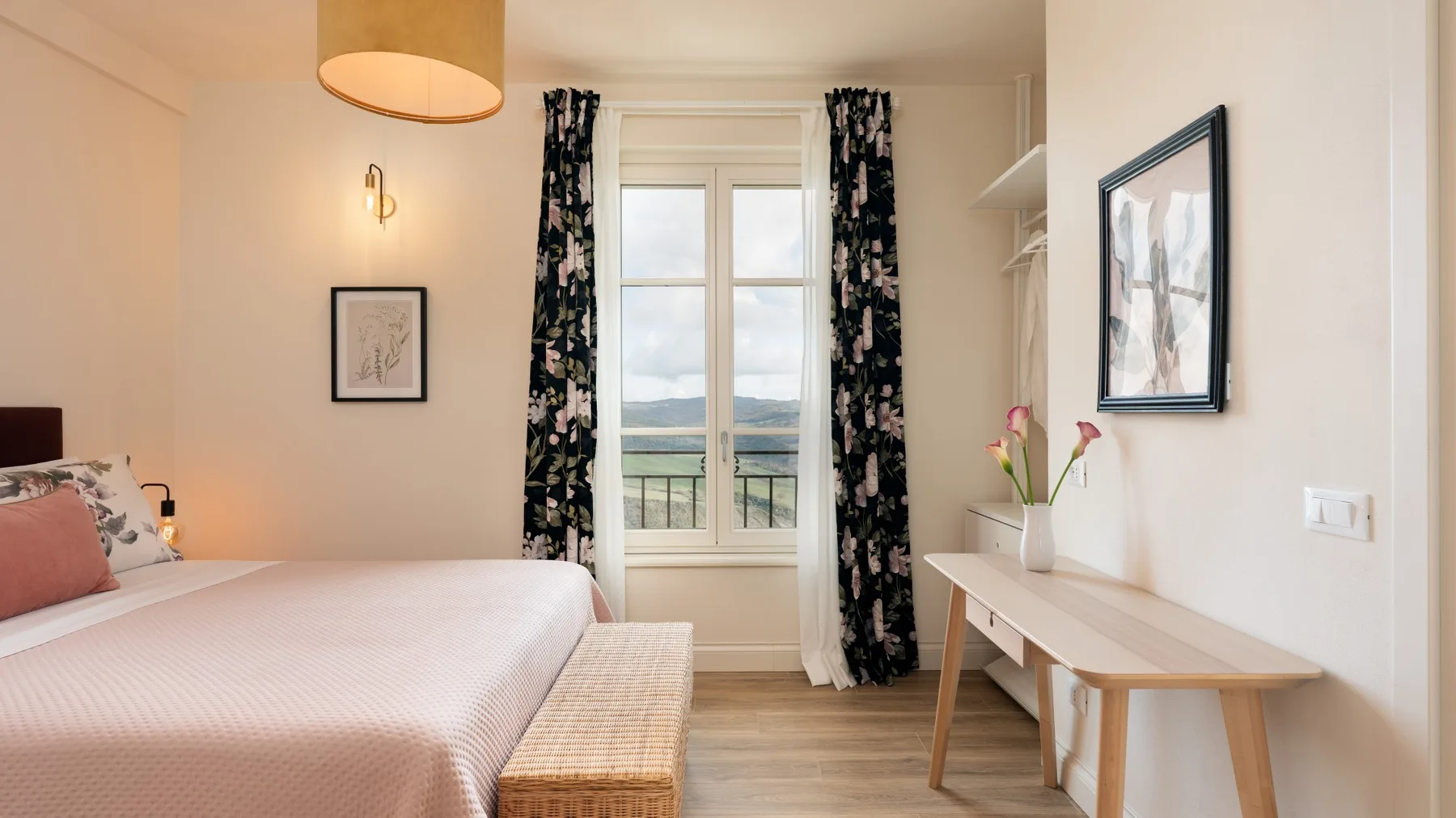 Un dormitorio luminoso con una cama, una ventana y un escritorio.