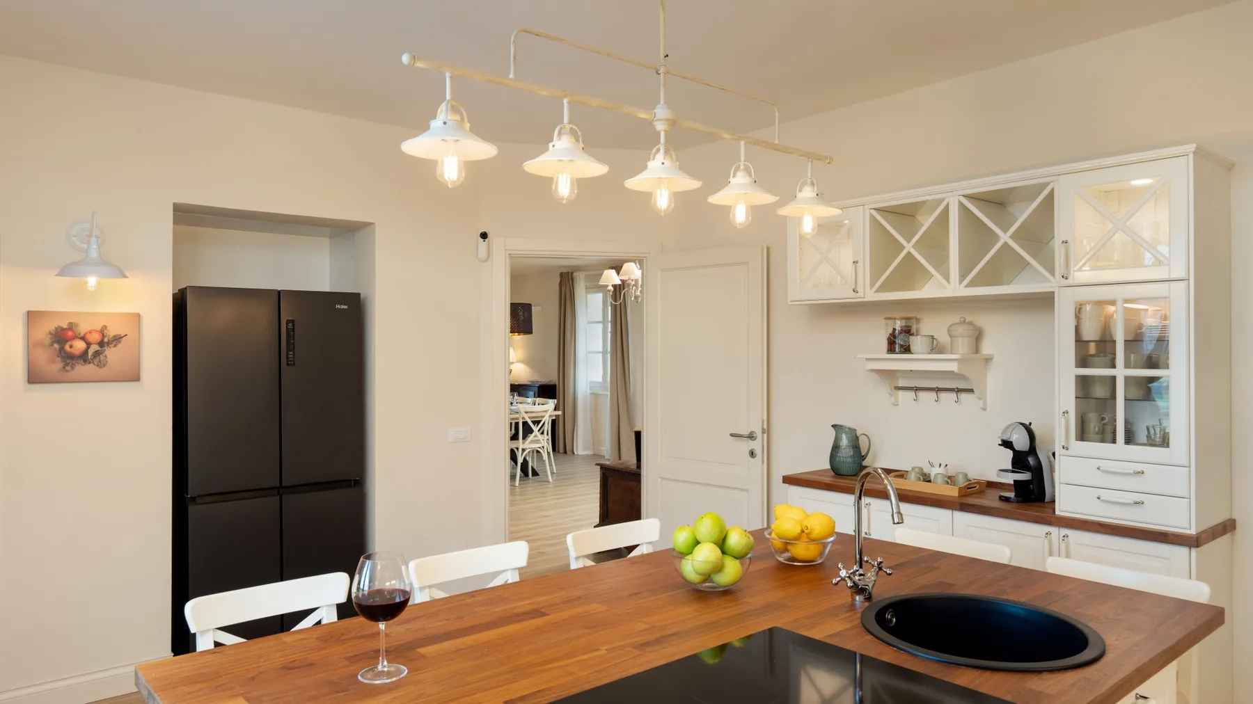 Una cocina luminosa con encimeras de madera y gabinetes blancos.