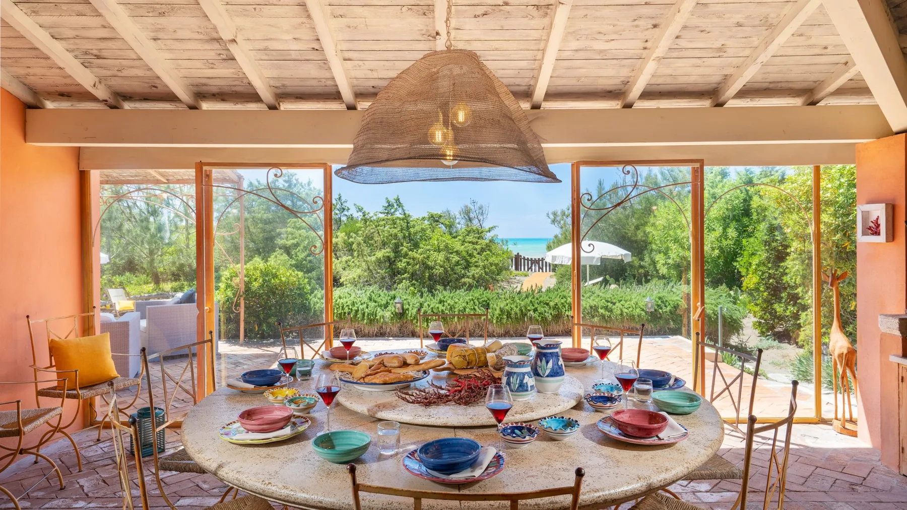 A dining area opens onto a garden through wide glass doors.