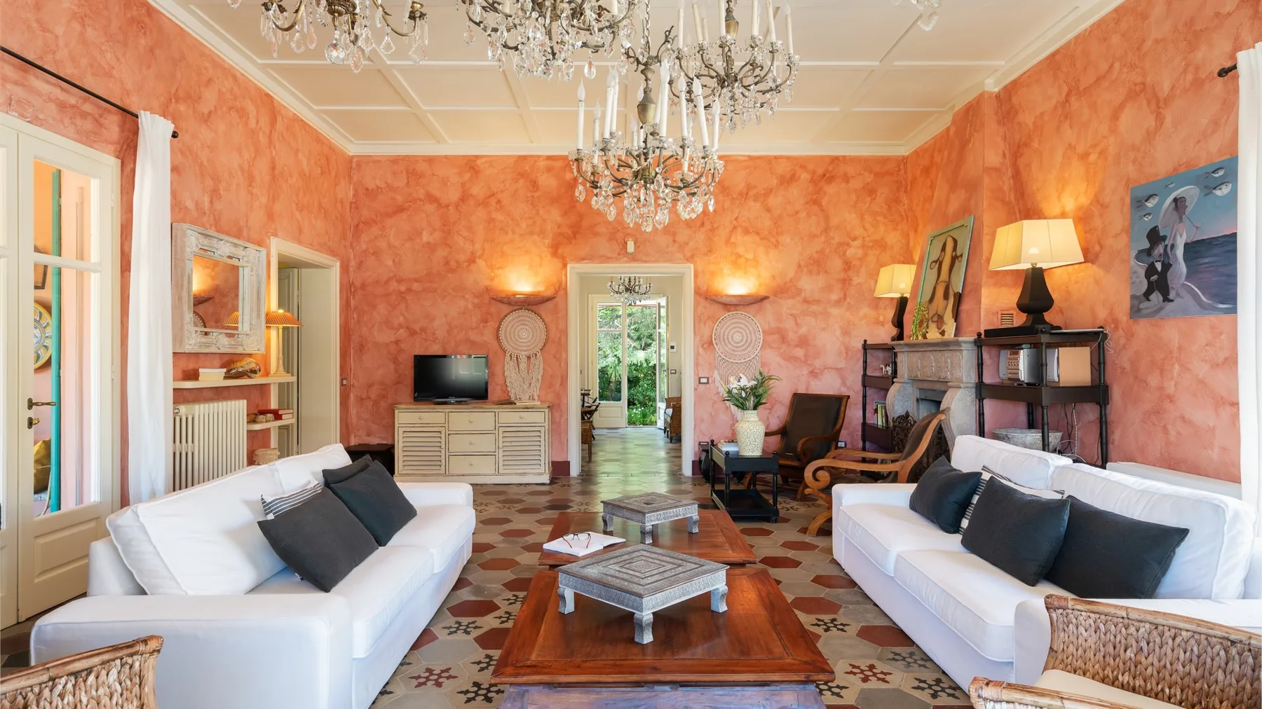 A bright living room with white seating arranged around a wooden coffee table.