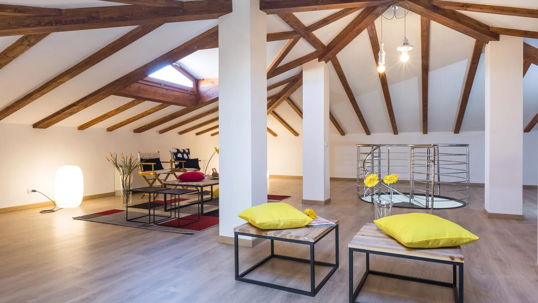 An open loft lounge with exposed wooden ceiling beams and seating.