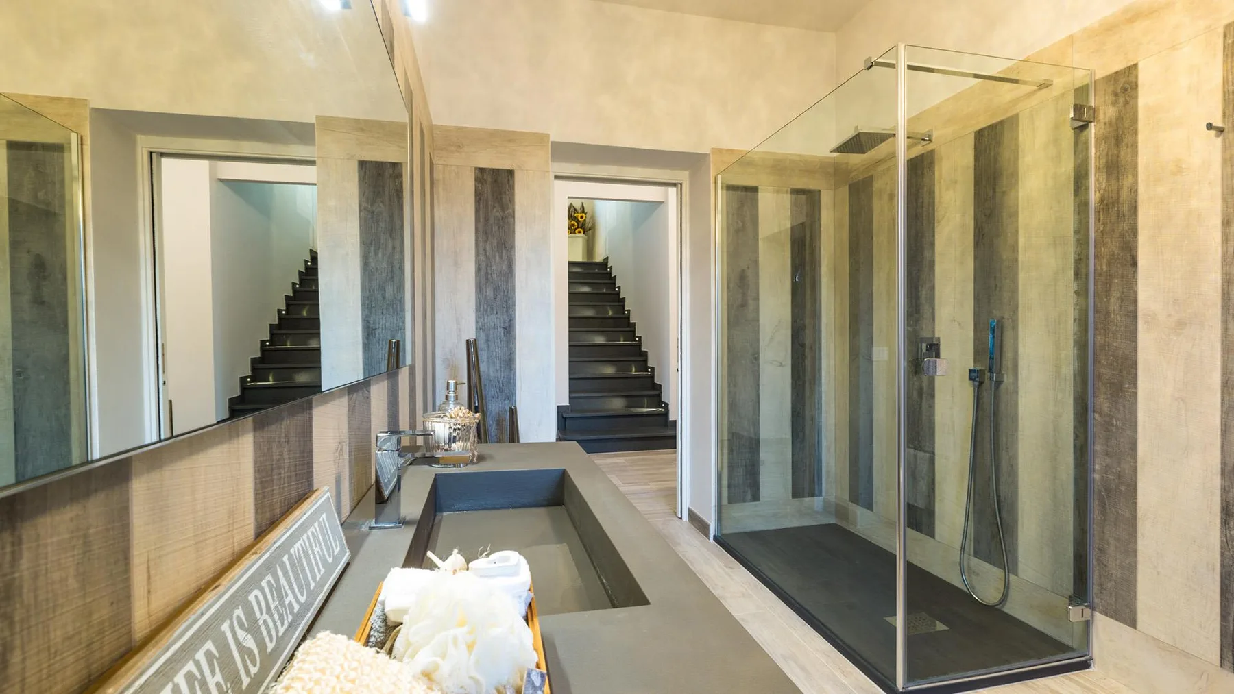 A modern bathroom with a double vanity and glass-enclosed shower.