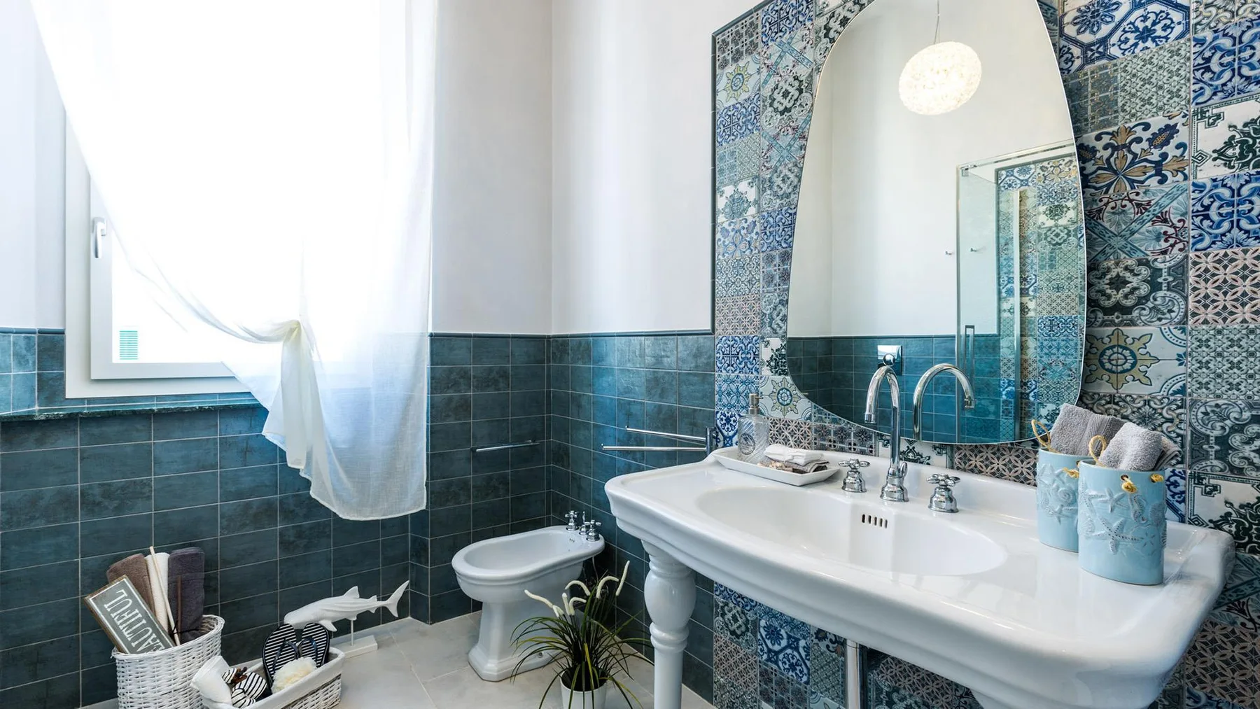 A tiled bathroom with a freestanding bathtub and a curtained window.