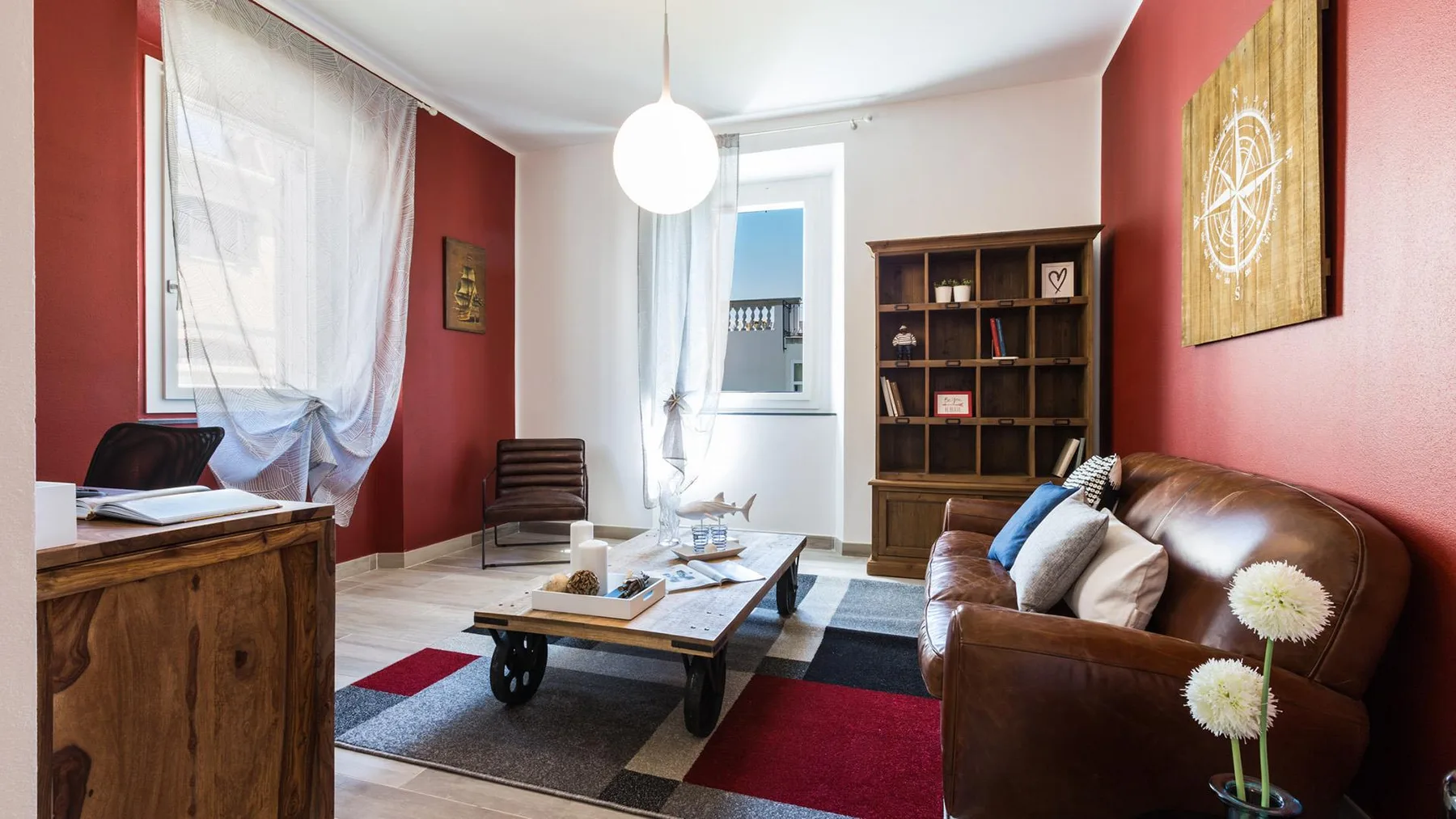 A living room with a brown sofa, coffee table, and large windows.