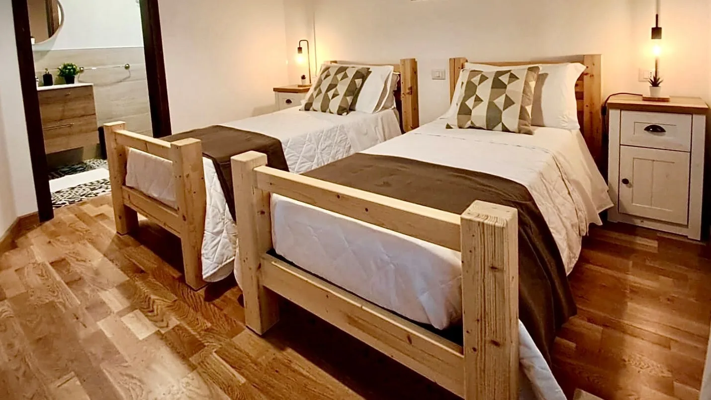 Un dormitorio con dos camas de madera y mesitas de noche a juego.