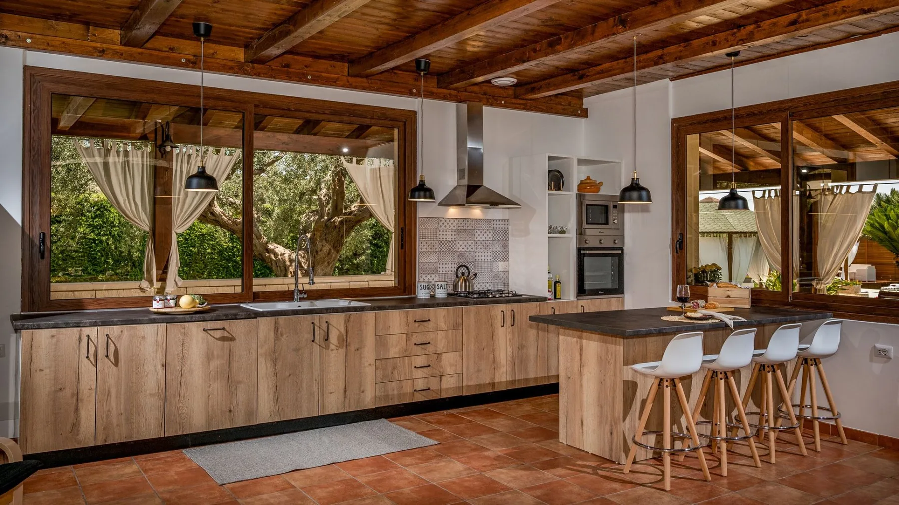 Una cocina con muebles de madera, una isla central y un techo de madera.