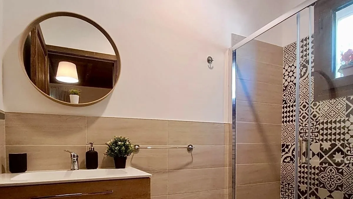 Un baño con lavabo y una ducha de vidrio.